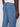 A close-up of a person wearing Projek Raws LUC-BLUE light blue linen drawstring pants with an elastic waistband and back pocket, paired with a white shirt for a relaxed vacation-ready look.