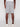 A person faces away, wearing Projek Raw GUSTAVE-ALLOY light gray knee-length shorts with two back welt pockets and visible stitching, paired with a white shirt and sneakers. The background is plain and light-colored.