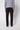 A person stands facing away in a light gray long-sleeve sweater, PROJEK RAW Mens 5-pocket Classic Stretch Bungee Pants, and black shoes, set against a plain light background.