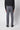 A person faces away from the camera, wearing PROJEK RAW Mens 5-pocket Classic Stretch Bungee Pants, a black long-sleeve top, and black shoes against a plain light background.
