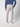 A man stands facing away in PROJEK RAW Mens Bungee Relaxed Chino Pant (light gray), a tucked-in blue long-sleeve shirt, and white sneakers against a plain light background.