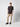 A young man with short hair stands against a plain light background, wearing a black tee, PROJEK RAW Men’s Stretch Bungee Cargo Jogger in beige, and black sneakers. He looks straight ahead with one hand in his pocket.