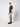 A man poses sideways against a plain light background, wearing a black textured t-shirt, PROJEK RAW Men’s Stretch Bungee Cargo Jogger in beige, and black sneakers. He looks slightly towards the camera with a neutral expression.