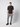 A young man in a black short-sleeve shirt and PROJEK RAW Men’s Stretch Bungee Cargo Jogger in light gray stands against a plain background, wearing black sneakers. He has one hand in his pocket and a neutral expression.