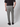 A person wearing a black short-sleeve shirt and PROJEK RAW Men’s Stretch Bungee Cargo Jogger with patch pockets and black shoes stands with their back to the camera against a light gray background.