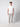 A young man faces forward in a plain white T-shirt, PROJEK RAW Mens Bungee Relaxed Cargo Pant in light gray, and white sneakers, set against a simple light gray background.