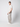 A young man stands sideways in a studio, wearing PROJEK RAW Mens Bungee Loose Cargo Pant with large pockets, paired with a white t-shirt and sneakers. His left hand is in his pocket against a plain light background.