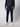 A person, head not visible, stands against a plain light background wearing a dark hoodie, PROJEK RAW Men’s Relaxed Chino Pant, and white sneakers.