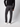 A person wearing a black long-sleeve top, PROJEK RAW Men’s Brushed Bungee 5-Pocket Pants, and white sneakers stands with their back to the camera against a plain light background.