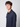 A young person with curly brown hair wears the PROJEK RAW Mens Long Sleeve Casual Dress Shirt in dark blue, standing against a plain light gray background and looking slightly to the side with a neutral expression.