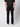 A person stands with their back to the camera against a plain light background, wearing a black shirt, PROJEK RAW Mens 5-Pocket Straight Fit Jean in black rinse, and white sneakers.