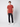 A young man with curly brown hair stands against a plain background, wearing a rust-colored short-sleeve tee, PROJEK RAW Mens 5 Pocket Slim Fit Jean in black, and white sneakers. He faces forward with a relaxed posture and neutral expression.