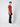 A young man stands sideways against a light background, wearing a rust tee, white sneakers, and PROJEK RAW Mens 5 Pocket Slim Fit Jean in black—these jeans deliver a sleek, modern style ideal for any casual occasion.