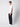 A young man with curly hair stands sideways in a plain white t-shirt, PROJEK RAW Mens Colored Denim Carpenter Pants with utility pockets in dark navy, and white sneakers against a light gray background.