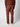 A person wearing a textured maroon sweater, PROJEK RAW Mens Colored Denim Carpenter Pants with side and back pockets, and white sneakers, seen from behind against a light gray background.
