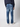 A man wearing PROJEK RAW Mens 5-Pocket Straight Fit Jeans in a blue faded wash, paired with a dark long-sleeve shirt and white sneakers, stands with his back to the camera against a plain light background.