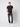 A young man stands against a light background, wearing a black t-shirt, PROJEK RAW Mens 5-Pocket Straight Fit Jeans, and white sneakers. One hand is in his pocket as he looks calmly at the camera.