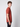 A young man with curly brown hair stands sideways, facing left, wearing a rust-colored PROJEK RAW Mens Short Sleeve Crewneck T-shirt and black jeans against a plain light gray background.