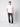 A young man stands against a plain background, wearing the PROJEK RAW Mens Short Sleeve Crewneck T-shirt with dark jeans and white sneakers, one hand in his pocket and a neutral expression.