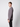 A young man with short light brown hair stands sideways, facing left, wearing a PROJEK RAW Mens Long Sleeve Crewneck T-shirt and black pants against a plain light gray background—a wardrobe staple.