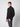 A young man with short brown hair wears a PROJEK RAW Mens Half-zip Cashmere Touch Sweater and gray plaid pants, standing against a plain light background, looking towards the camera with a neutral expression.