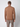 A man faces away from the camera, wearing a PROJEK RAW Mens Long Sleeve Turtleneck Sweater in light brown with gray pants, set against a plain, light background.