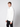 A young man in a PROJEK RAW Mens Zip Mock Neck Sweater and black pants stands against a plain light gray background, gazing to the side with a neutral expression.