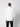 A man faces away from the camera, wearing a PROJEK RAW Mens Zip Mock Neck Sweater in white and black pants, set against a plain light gray background.