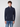 A young man with curly brown hair wears a navy blue PROJEK RAW Mens Zip Mock Neck Sweater and blue jeans, standing against a plain light gray background and looking directly at the camera with a neutral expression.