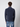 A person with short, curly brown hair stands with their back to the camera, wearing a PROJEK RAW Mens Zip Mock Neck Sweater in dark blue and light blue jeans against a plain light gray background.