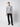 A man stands against a plain light background, facing forward with a neutral expression, wearing the PROJEK RAW Mens Cable Knit Mock Neck Sweater in gray and white marled knit, paired with black pants and black shoes.