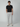 A man with curly hair stands against a plain backdrop, wearing a PROJEK RAW Mens Solid Bungee Cargo Jogger with an elastic waistband and cargo pockets, paired with a black t-shirt and white sneakers. His hands are in his pockets as he faces forward.
