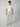 A young man stands against a plain light gray background, wearing PROJEK RAW Mens Drawstring Chino Pant with a white short-sleeve T-shirt and beige slip-on shoes. He faces forward with a neutral expression.
