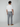 A man faces away from the camera in a white T-shirt and PROJEK RAW MENS 5-POCKET PANT made of stretch fabric, paired with tan shoes, set against a plain light gray background.