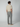 A man stands facing away from the camera, wearing a beige short-sleeve shirt and PROJEK RAW Mens Drawstring Linen Pant with beige shoes against a plain, light-colored background.