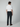 A man faces away from the camera, wearing a white short-sleeve t-shirt, brown shoes, and PROJEK RAW MENS 5-POCKET ATHLETIC FIT JEAN against a plain light background.
