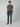 A young man faces forward, wearing a plain olive green t-shirt, PROJEK RAW BARU MENS 5-POCKET JEAN in tailored-fit stretch denim blue, and brown shoes against a simple light gray background.