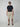A man in sunglasses, a dark navy t-shirt, PROJEK RAW Mens Solid Bungee Pull-on Cargo Shorts with an elastic waistband, and brown sandals stands facing forward against a plain light background.