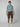 A young man faces forward in a light blue t-shirt, PROJEK RAW Mens Solid Bungee Pull-on Cargo Shorts, and white sneakers, set against a plain light gray background.