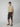 A young man, facing the camera with a neutral expression, wears a beige t-shirt and PROJEK RAW Mens Solid Bungee Pull-on Cargo Shorts. The elastic waistband shorts offer relaxed comfort—ideal for casual everyday wear.