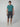 A young man faces forward in a teal short-sleeve t-shirt, PROJEK RAW Mens Solid Bungee Capri Cargo Shorts 13 Inseam, and white sneakers, set against a plain light gray background.