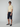 A man stands against a plain background wearing sunglasses, a short-sleeved beige polo shirt with a chest pocket, PROJEK RAW Mens Solid Bungee Capri Cargo Shorts 13 Inseam in navy, and navy slip-on shoes.