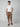 A man stands against a plain background wearing a white t-shirt and PROJEK RAW MENS CAPRI CARGO SHORT with brown sandals. His left hand is in his pocket, and he has a neutral expression.