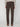 A person faces away, wearing PROJEK RAW MENS 5-POCKET SOLID BUNGEE PANT in dark brown—classic fit with flap back pockets. Styled with a light beige sweater and brown shoes, the outfit pops against a simple, light background.