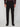 A person is shown from the shoulders down wearing PROJEK RAW MENS 5-POCKET SOLID BUNGEE CHINO PANT in black, paired with a dark long-sleeve shirt and black dress shoes, set against a plain light background.