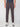 A person wearing PROJEK RAW MENS SOLID BUNGEE FASHION CHINO PANT in dark gray and light sneakers stands against a white background. The cropped image shows them from shoulders to feet, hands relaxed at their sides.