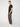 A person stands sideways against a plain light background, wearing the PROJEK RAW MENS SOLID BUNGEE CARGO JOGGER with cargo pockets and elasticized waistband, a black short-sleeve shirt, and white sneakers, with one hand in their pocket.