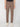 A person models the PROJEK RAW MENS SOLID BUNGEE RELAXED 5-POCKET PANT in light brown with white sneakers, lower torso and legs visible, standing against a plain white background.