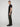 A person with short light brown hair stands in profile against a plain light background, wearing a black t-shirt, black shoes, and PROJEK RAW MENS SOLID BUNGEE RELAXED CARGO PANT.