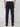 A person wearing PROJEK RAW MEN’S RELAXED BUNGEE TWILL CHINO PANT in dark navy with black shoes is seen from the back against a plain light gray background.